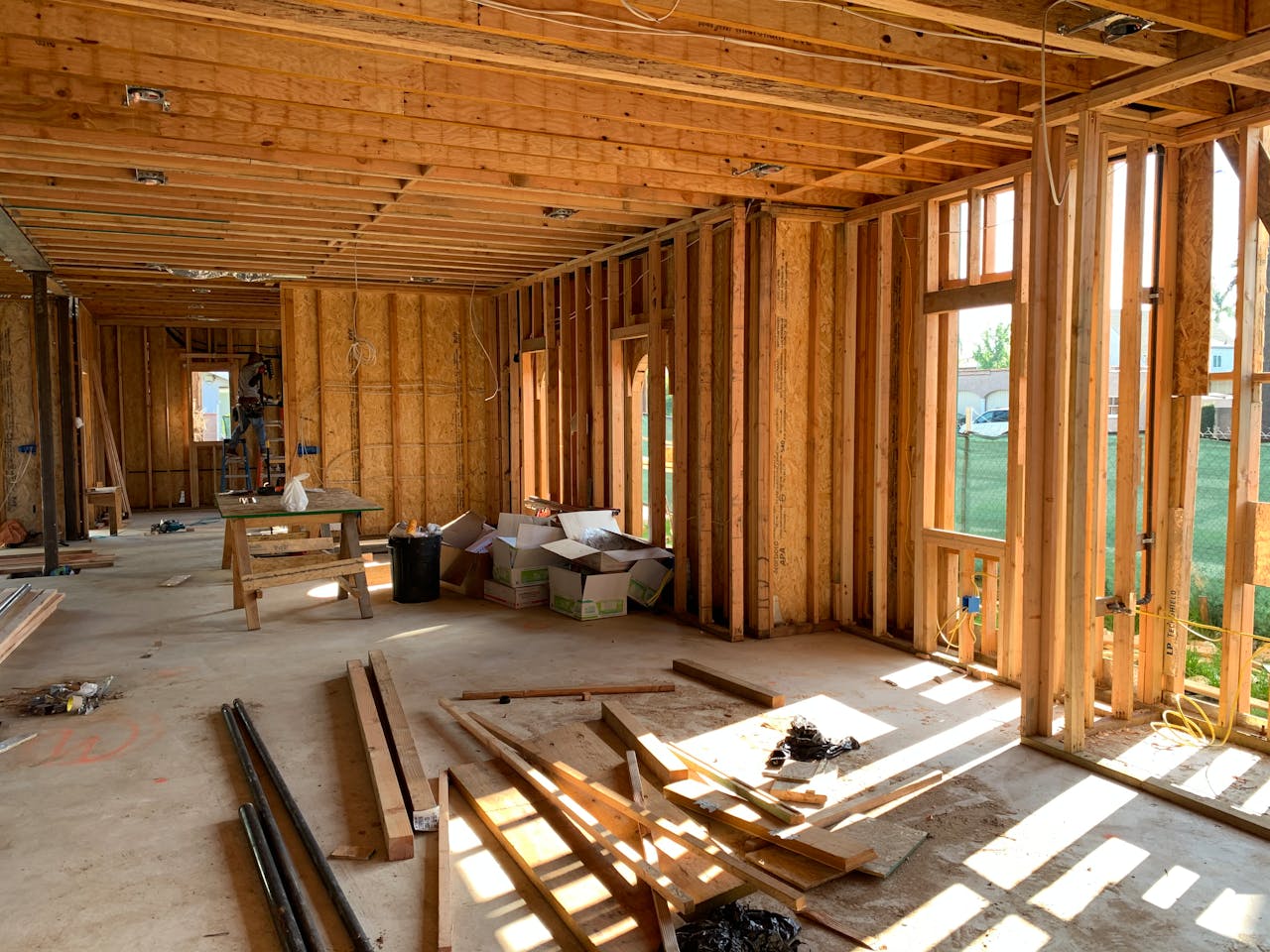services-05 Sunlit interior with wood framing, showcasing home construction progress.